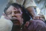Первая фотография Каддафи в день его смерти, которую распространили арабские и западные информационные агентства. При поимке диктатор якобы кричал: «Не стреляйте, не стреляйте». Погиб диктатор не сразу. Как утверждает источник AFP в руководстве операции, лично видевший Каддафи, диктатор сначала был тяжело ранен, но «все еще дышал». По словам этого же источника, экс-лидер Ливии был одет в военно-полевую форму и тюрбан.