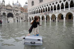 Туристка со своим чемоданом на затопленной площади Святого Марка в Венеции, 13 ноября 2019 года