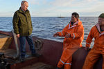 Президент РФ Владимир Путин (слева) во время посещения рыболовецкой лодки на озере Ильмень