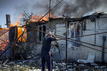 Местный житель во время тушения пожара в одном из домов в станице Луганская, подвергшейся авиационному удару вооруженных сил Украины