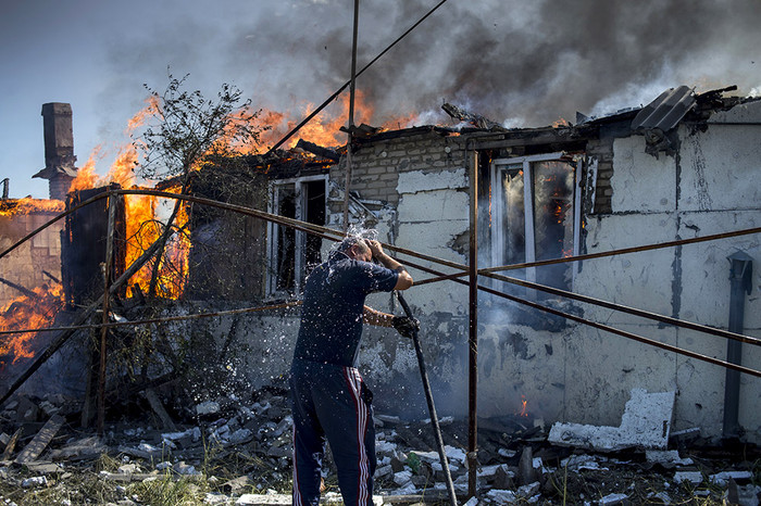 Местный житель во время тушения пожара в&nbsp;одном из&nbsp;домов в&nbsp;станице Луганская, подвергшейся авиационному удару вооруженных сил Украины