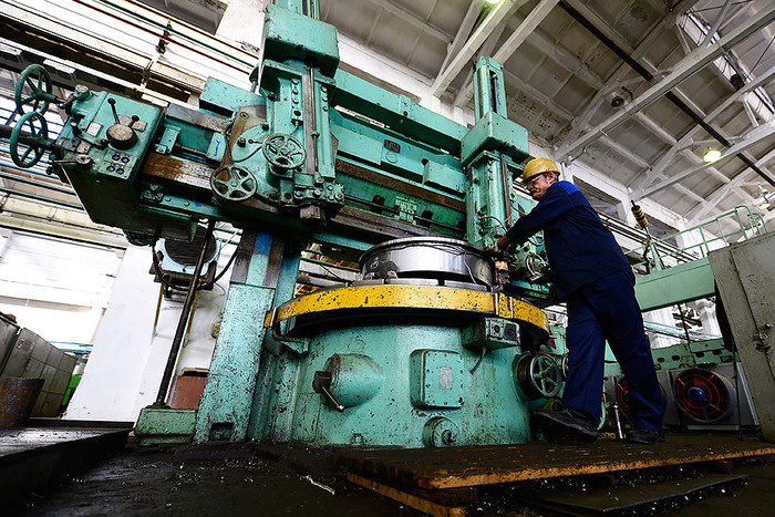 Работник цеха дальневосточного завода «Звезда» во время обработки машиностроительных деталей, которые применяются при строительстве и ремонте подводных лодок