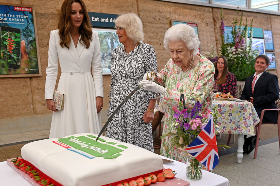 Королева Великобритании Елизавета II разрезает торт церемониальной саблей в&nbsp;ботаническом саду «Эден» в&nbsp;графстве Корнуолл. Рядом &mdash; герцогиня Кембриджская Кэтрин и герцогиня Корнуолльская Камилла