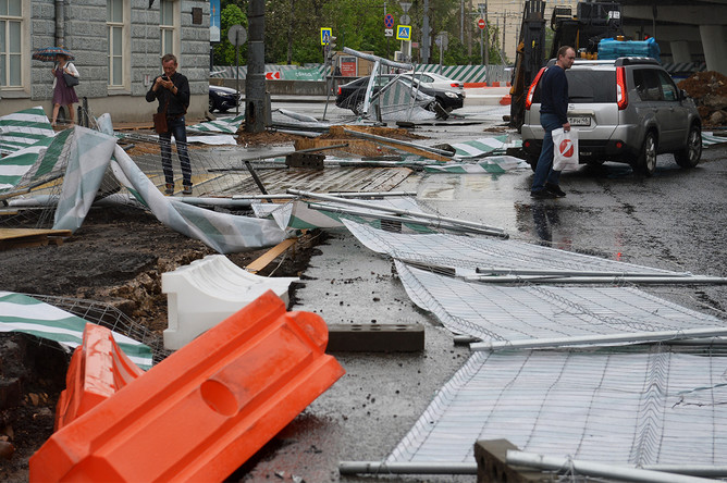 Сорванный ураганом заградительный забор на улице Остоженка в Москве