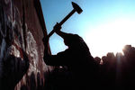 Человек разбивает Берлинскую стену, 12 ноября 1989 года