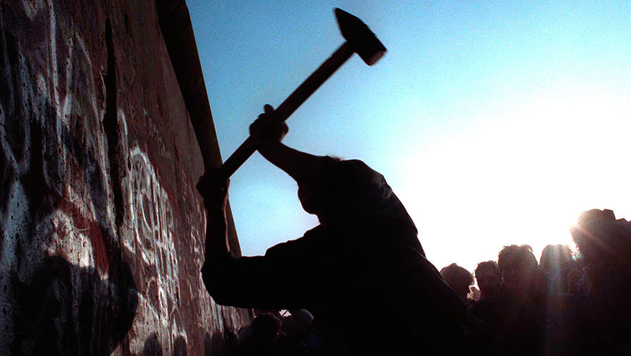 Человек разбивает Берлинскую стену, 12 ноября 1989 года