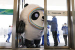 Человек в костюме маскота зимней Олимпиады 2022 пытается пройти в дверь главного медиацентра, Пекин, январь 2022 года
