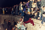 Люди поднимаются на Берлинскую стену 10 ноября 1989 года возле Бранденбургских ворот
