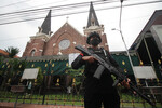 Индонезия. Вооруженный полицейский охраняет вход в церковь перед рождественской мессой в Сурабае (Восточная Ява)