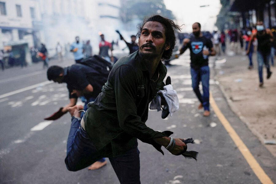 Протестующий бросает гранату со слезоточивым газом в&nbsp;сторону полиции во время разгона демонстрации с&nbsp;требованием отставки президента Готабая Раджапаксы в&nbsp;Коломбо, Шри-Ланка, 8&nbsp;июля 2022&nbsp;года