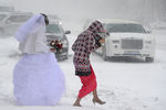 Невеста идет по улице во время сильного снегопада