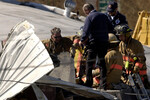 Пожарные пробивают отверстие в крыше бульдозера, которым управлял Марвин Химейер, 5 июня 2004 года