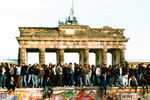 Граждане обеих частей Берлина стоят на Берлинской стене возле Бранденбургских ворот в день объединения Германии, 10 ноября 1989 года