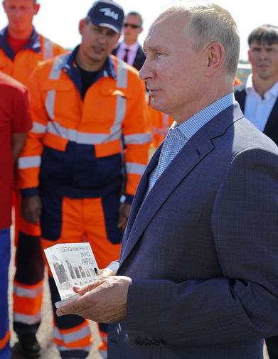 Президент России Владимир Путин беседует с дорожниками, которые принимали участие в строительстве...