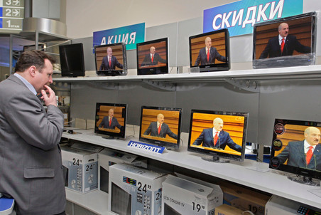 Посетитель магазина электроники слушает выступление президента Белоруссии Александра Лукашенко.