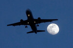 Самолет на фоне растущей луны заходит на посадку в Чикагском международном аэропорту О'Хара, США, 21 февраля 2024 года