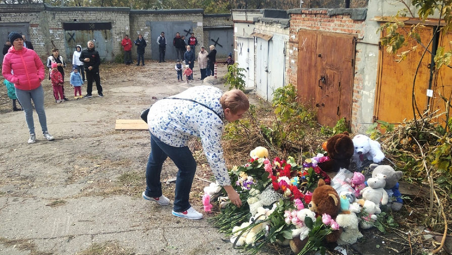 Жители города несут мягкие игрушки и цветы к&nbsp;гаражному комплексу, где было найдено тело ранее пропавшей 9-летней девочки, 11 октября 2019 года