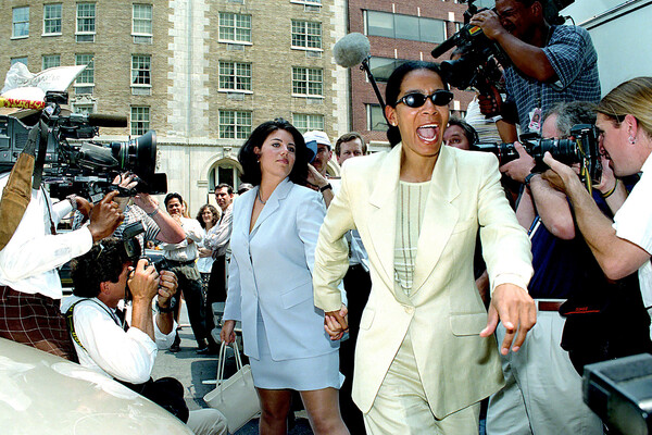 Моника Левински со своим представителем Джуди Смит следуют сквозь толпу журналистов в&nbsp;адвокатский офис в&nbsp;Вашингтоне, 1998&nbsp;год