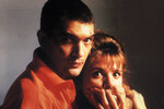 <b>«Свяжи меня!» (1989)</b>
<br><br>
Это пятая совместная работа Антонио Бандераса и Педро Альмодовара — и одна из самых значимых. После нее актер отправился работать в Голливуд.
На этот раз ему досталась главная роль — молодого сироты по имени Рики, который только что выписался из психиатрической клиники. Он пытается начать новую жизнь, но довольно странным образом — похитив актрису порнофильмов Марину, с которой один раз имел интимную связь. Привязав ее к кровати, он надеется заставить женщину себя полюбить. А тем временем отлучается, влипает в неприятности — и когда он возвращается окровавленным, Марина действительно начинает испытывать к нему какое-то теплое чувство.
