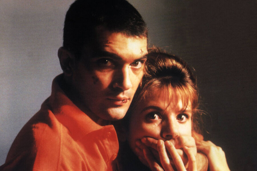 <b>«Свяжи меня!» (1989)</b>
<br><br>
Это пятая совместная работа Антонио Бандераса и Педро Альмодовара &mdash; и одна из&nbsp;самых значимых. После нее актер отправился работать в&nbsp;Голливуд.
На&nbsp;этот раз ему досталась главная роль &mdash; молодого сироты по&nbsp;имени Рики, который только что выписался из&nbsp;психиатрической клиники. Он пытается начать новую жизнь, но довольно странным образом &mdash; похитив актрису порнофильмов Марину, с&nbsp;которой один раз имел интимную связь. Привязав ее к&nbsp;кровати, он надеется заставить женщину себя полюбить. А тем временем отлучается, влипает в&nbsp;неприятности &mdash; и когда он возвращается окровавленным, Марина действительно начинает испытывать к&nbsp;нему какое-то теплое чувство.
