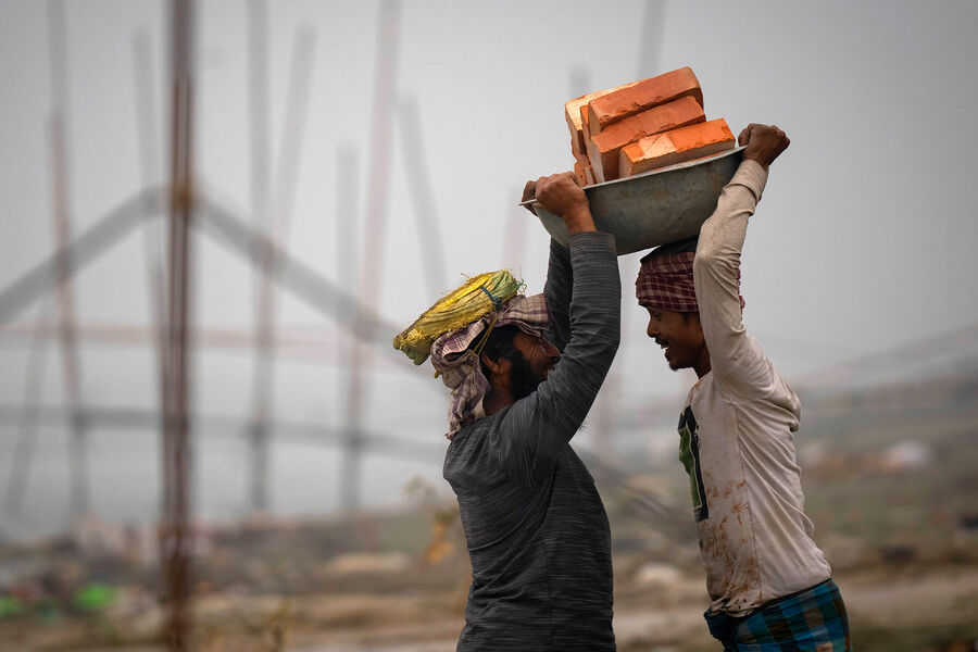 Рабочие несут кирпичи в&nbsp;Гувахати, Индия, 21&nbsp;февраля 2023&nbsp;года