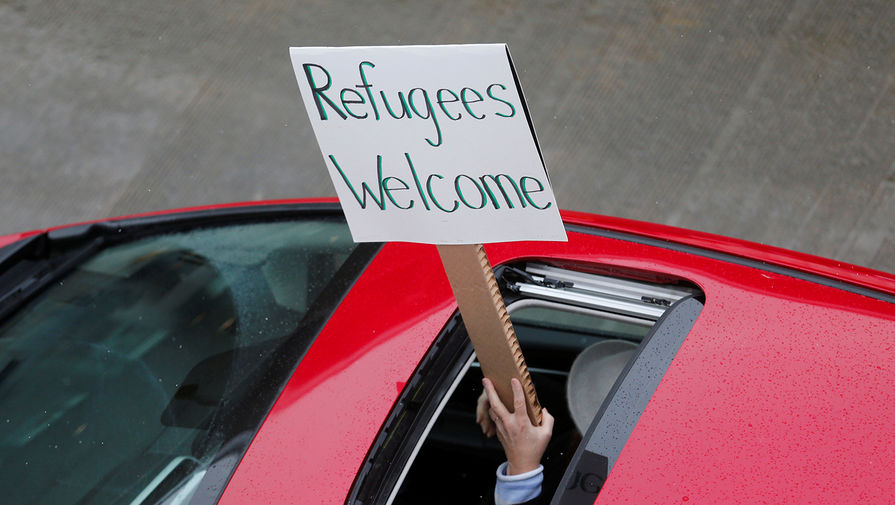 Во время массовых протестов против миграционного указа Дональда Трампа в Детройте, штат Мичиган, 29 января 2017 года. Надпись на плакате: «Беженцы, добро пожаловать»