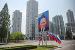 Баннер с портретом президента РФ Владимира Путина и российские флаги на улице в Пхеньяне, 18 июня 2024 года