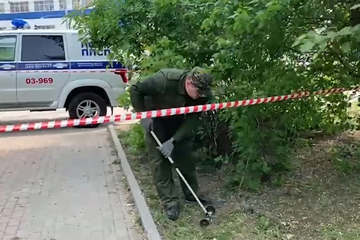 Сотрудник правоохранительных органов во время работы в парке возле железнодорожного вокзала, где убили трех человек, 17 мая 2021 года 