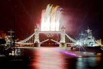 Спортивная лодка провозит олимпийский огонь по Темзе под Тауэрским мостом 27 июля 2012 года во время открытия летних Олимпийских игр 2012 года в Лондоне. В эти дни сам мост был украшен олимпийскими кольцами