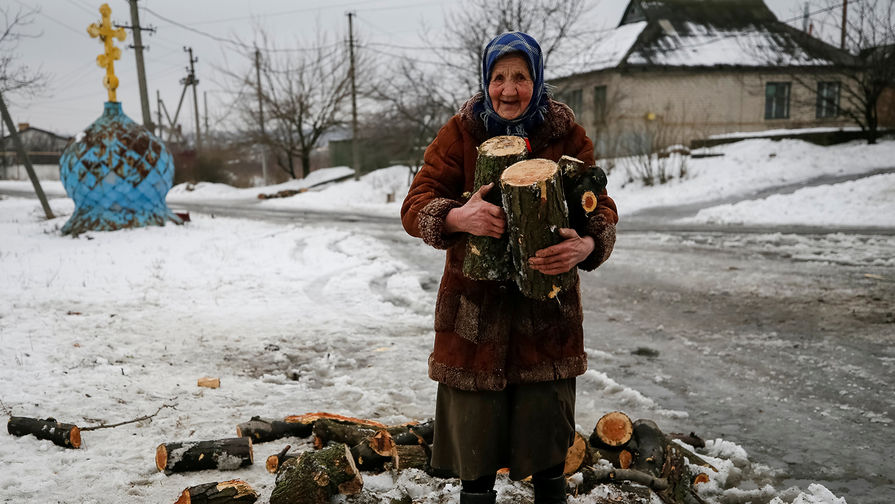 Пожилая женщина с дровами в Авдеевке, Украина, февраль 2017 года