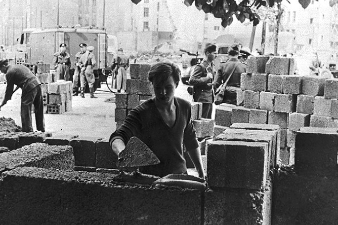 Рабочий закладывает первые камни Берлинской стены, 13 августа 1961 года