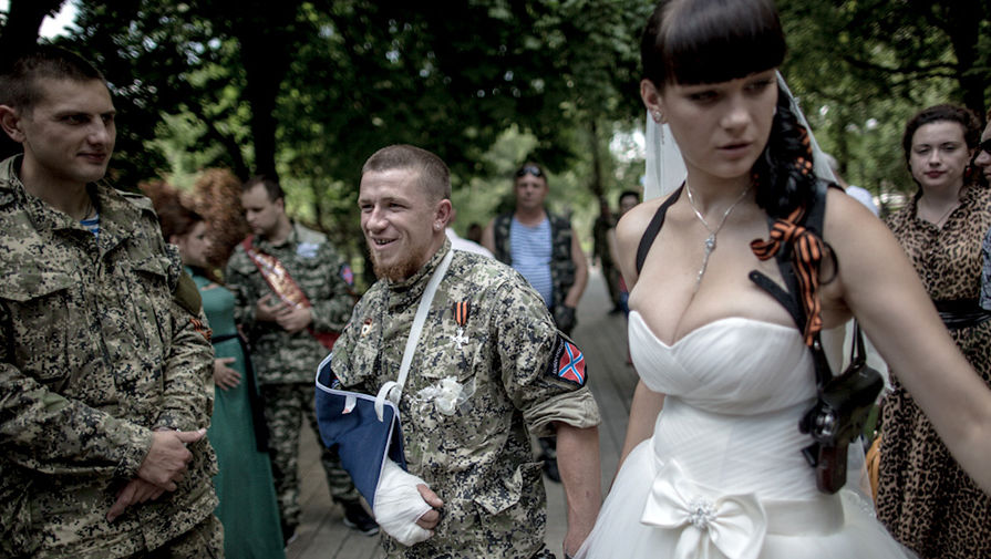 Боец народного ополчения с позывным Моторола (в центре) и его супруга Елена после бракосочетания в ЗАГСе города Донецка, 11 июля 2014 года 