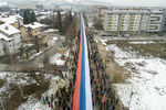 Боснийские сербы маршируют с гигантским национальным флагом во время несанкционированного парада в Сараево, Босния, 9 января 2022 года