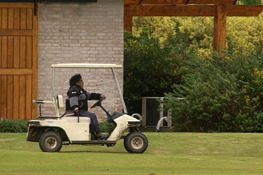 Легенда аргентинского футбола Диего Марадона едет на гольф-каре в поместье Хенераль-Родригес недалеко от Буэнос-Айреса, Аргентина, 1 мая 2004 года