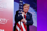 Дональд Трамп обнимает флаг США на CPAC 2019, 2 марта 2019 года