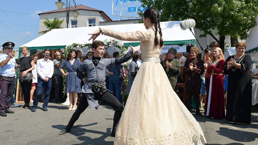 Молодые люди танцуют лезгинку на выставке сельхозпродукции, посвященной празднованию 10-летней годовщины признания Россией независимости Абхазии, на площади Сергея Багапш в Сухуме