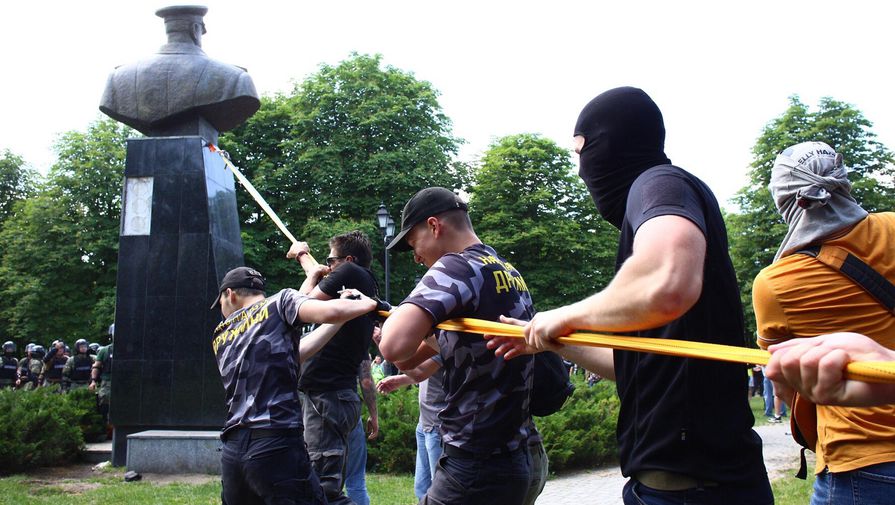 Представители националистических организаций с помощью троса пытаются повалить бюст маршала Георгия Жукова в Харькове возле Дворца спорта, 2 июня 2019 года