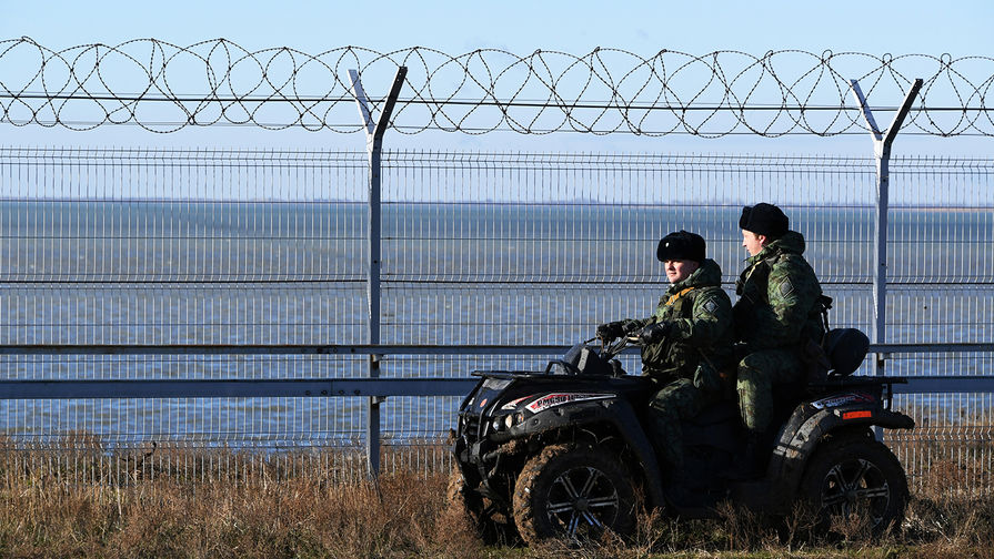 Российские пограничники у заграждения, возведенного в Крыму на границе с Украиной, 28 декабря 2018 года