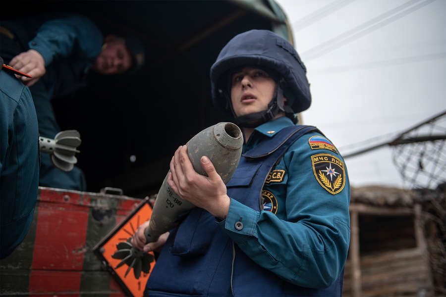 Саперы МЧС ЛНР грузят в машину снаряды, обнаруженные в ходе обследования территории Луганской теплоэлектростанции, которая была заминирована украинскими силовиками, в городе Счастье, 31 марта 2022 года