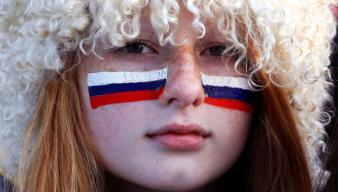 Фанатка из России во время хоккейной игры между российской и финской командами на Олимпиаде в Сочи...