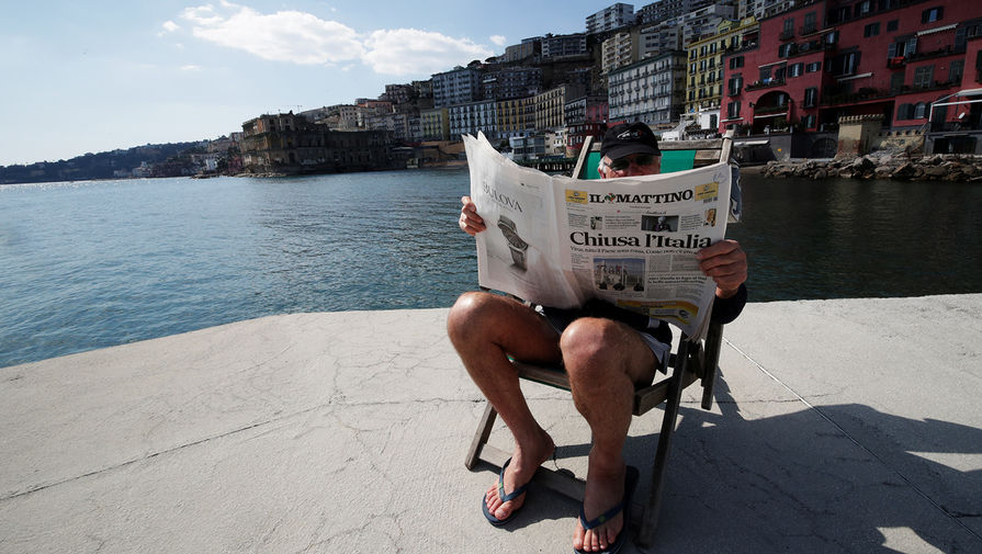 Местный житель читает газету в Неаполе, Италия, 10 марта 2020 года