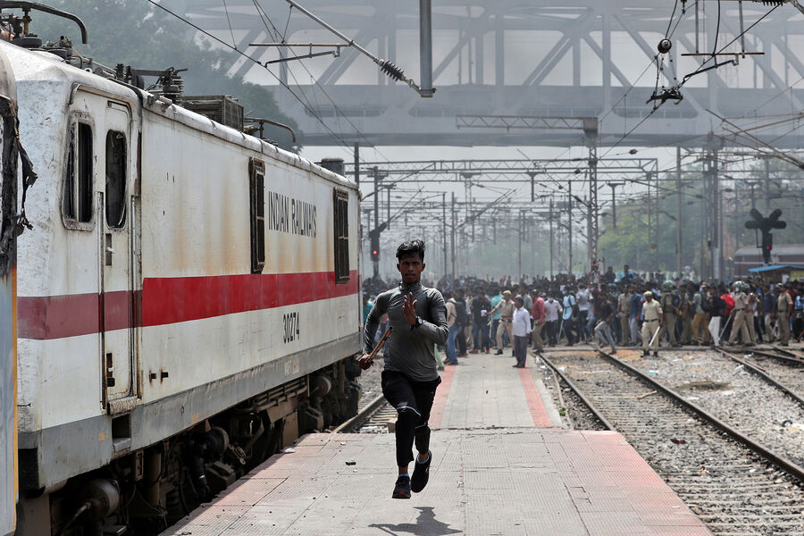 Протестующий против новой краткосрочной схемы набора в&nbsp;армию убегает, услышав выстрелы, во время беспорядков на&nbsp;железнодорожной станции Секундерабад в&nbsp;Хайдарабаде, Индия, 17&nbsp;июня 2022&nbsp;года