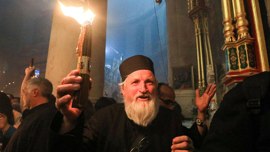 Верующие празднуют схождение Благодатного огня накануне православной Пасхи в храме Гроба Господня в Иерусалиме, 27 апреля 2019 года