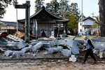 Мужчина проходит мимо поврежденного храма после землетрясения в Удзиме, 2 января 2024 года 