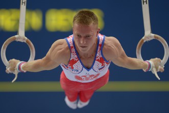 Денис Аблязин выполняет упражнение на кольцах