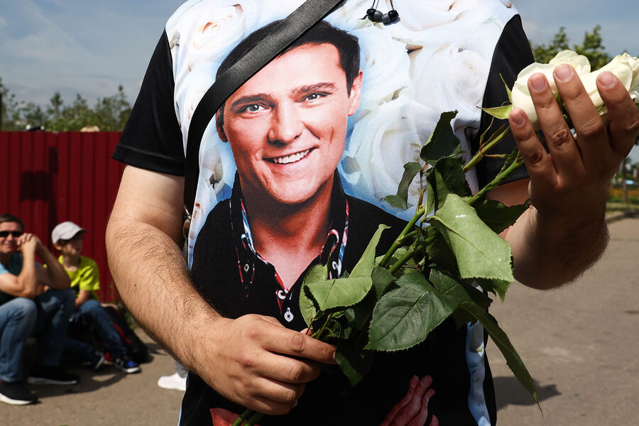 Портрет бывшего солиста группы «Ласковый май» Юрия Шатунова на футболке фаната во время панихиды на Троекуровском кладбище, 2022 год