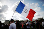 Мужчина на церемонии прощания с Жан-Полем Бельмондо держит французский флаг со словами «Бебель Великолепный, спасибо тебе», 9 сентября 2021 год