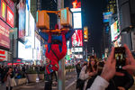 Человек в костюме Человека-паука висит на светофоре на Тайм-Сквер в Нью-Йорке