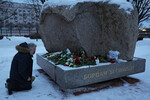 Мужчина возлагает цветы к Соловецкому камню в память об Алексее Навальном после сообщения о его смерти в колонии, Санкт-Петербург, 16 февраля 2024 года