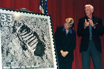 Астронавт Юджин Сернан и представитель американской почты во время презентации марки «Человек идет по луне» в космическом центре Кеннеди, июль 1999 года